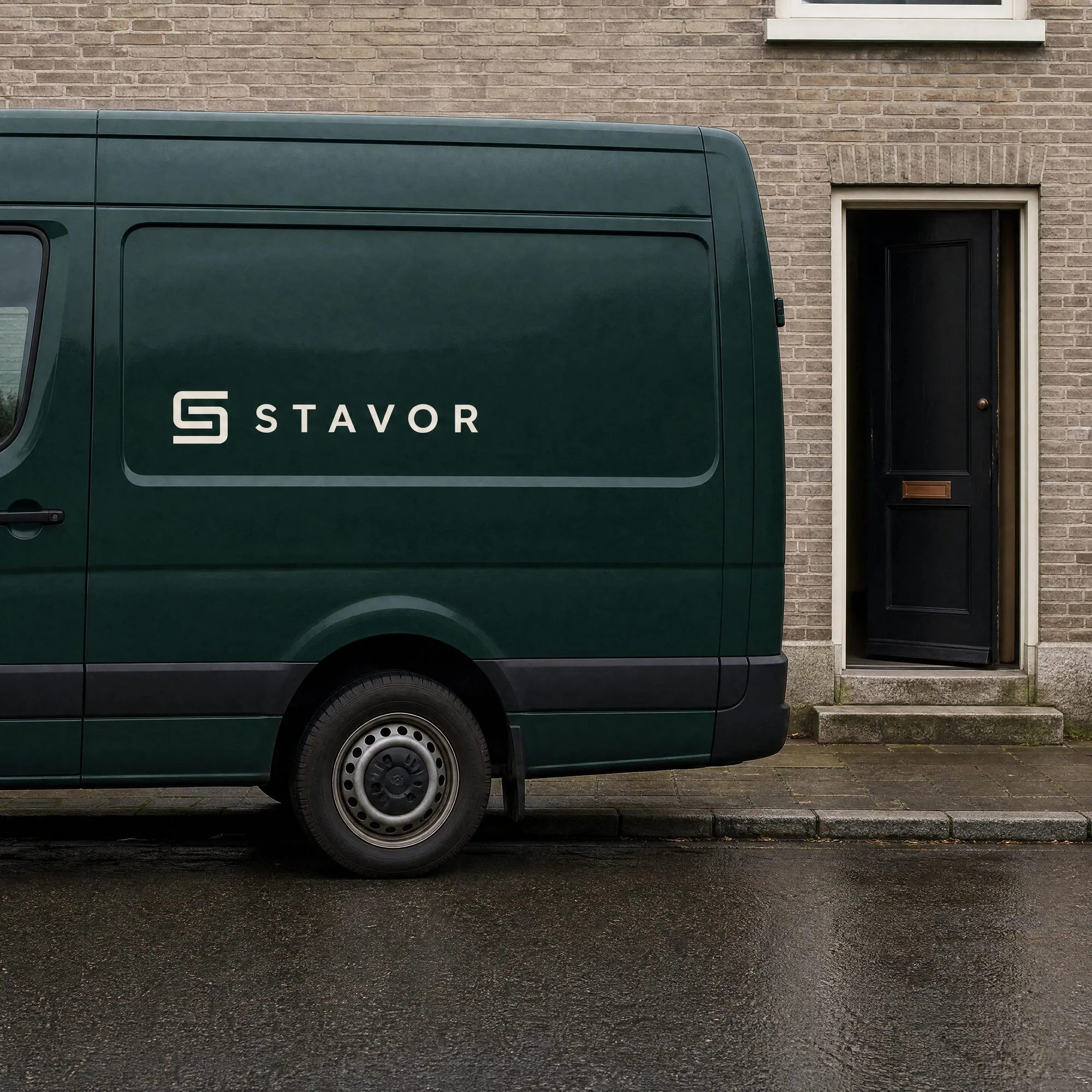De donkergroene bus van Stavor met het logo op de flank, geparkeerd voor de voordeur van een woning